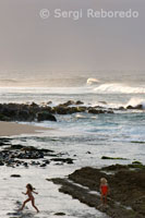 Niñas jugando al atardecer en Ho’okipa Beach, una de las mejores playas donde practicar el windsurf y el surf.